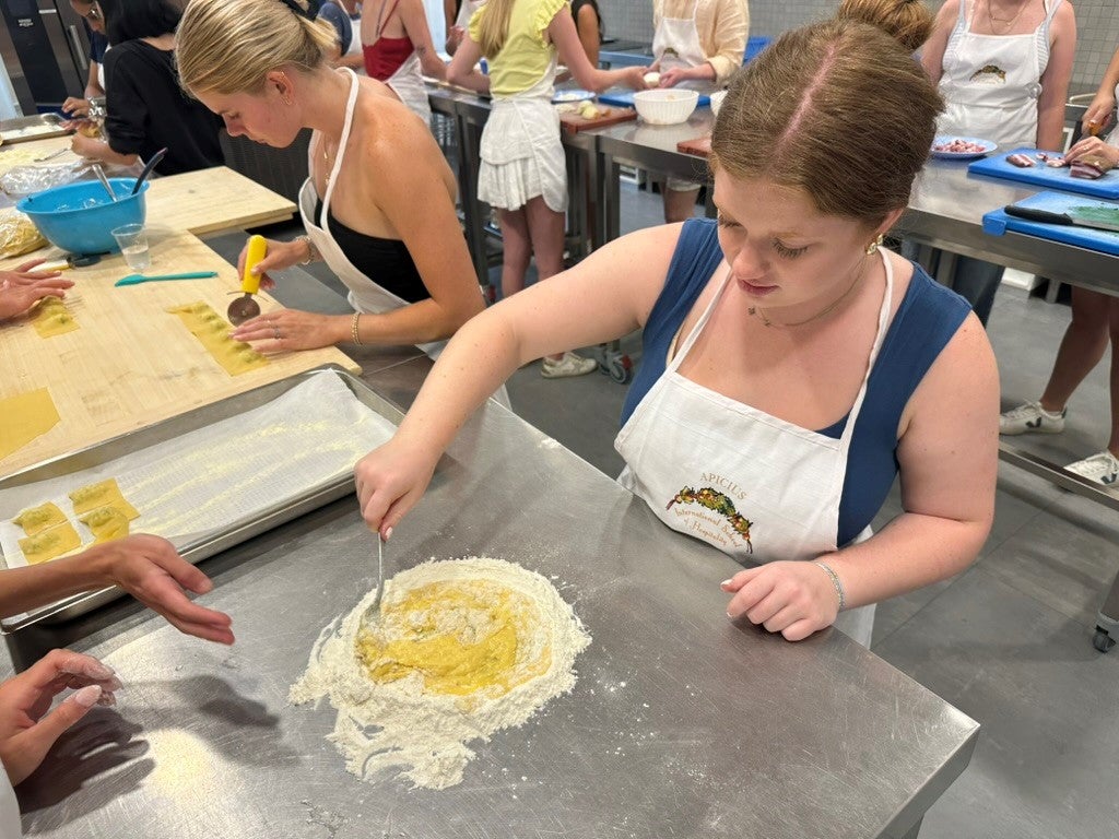 A student in the Italian Food and Culture class makes dough.