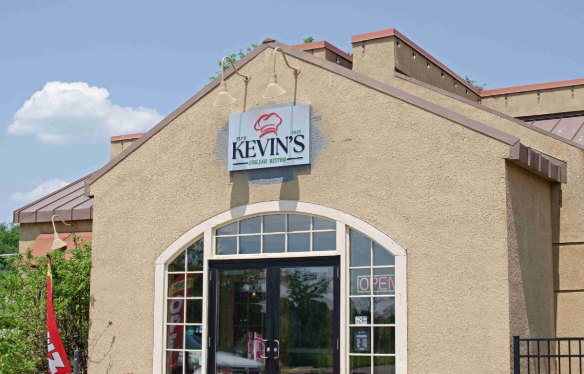 Kevin's Italian Bistro, a beige stucco restaurant, stands at 6399 City West Parkway in front of a bright blue sky with fluffy clouds.