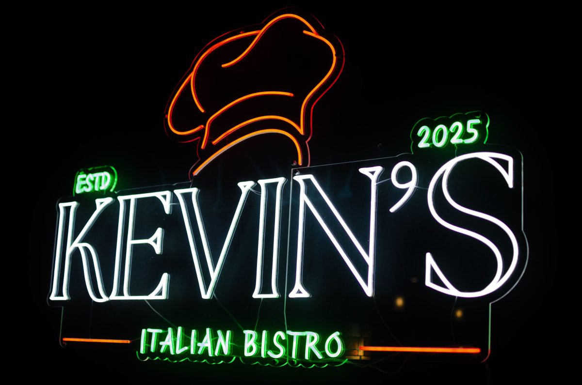 A neon sign in the colors of the Italian flag reads "Kevin's Italian Bistro."