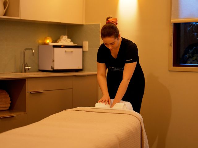 woman setting up massage room at kingfisher bay resort Island Day Spa