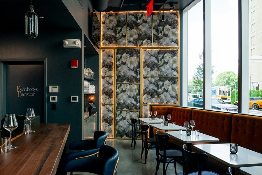 A bold floral wall hides wine storage at Nathálie Wine Bar.