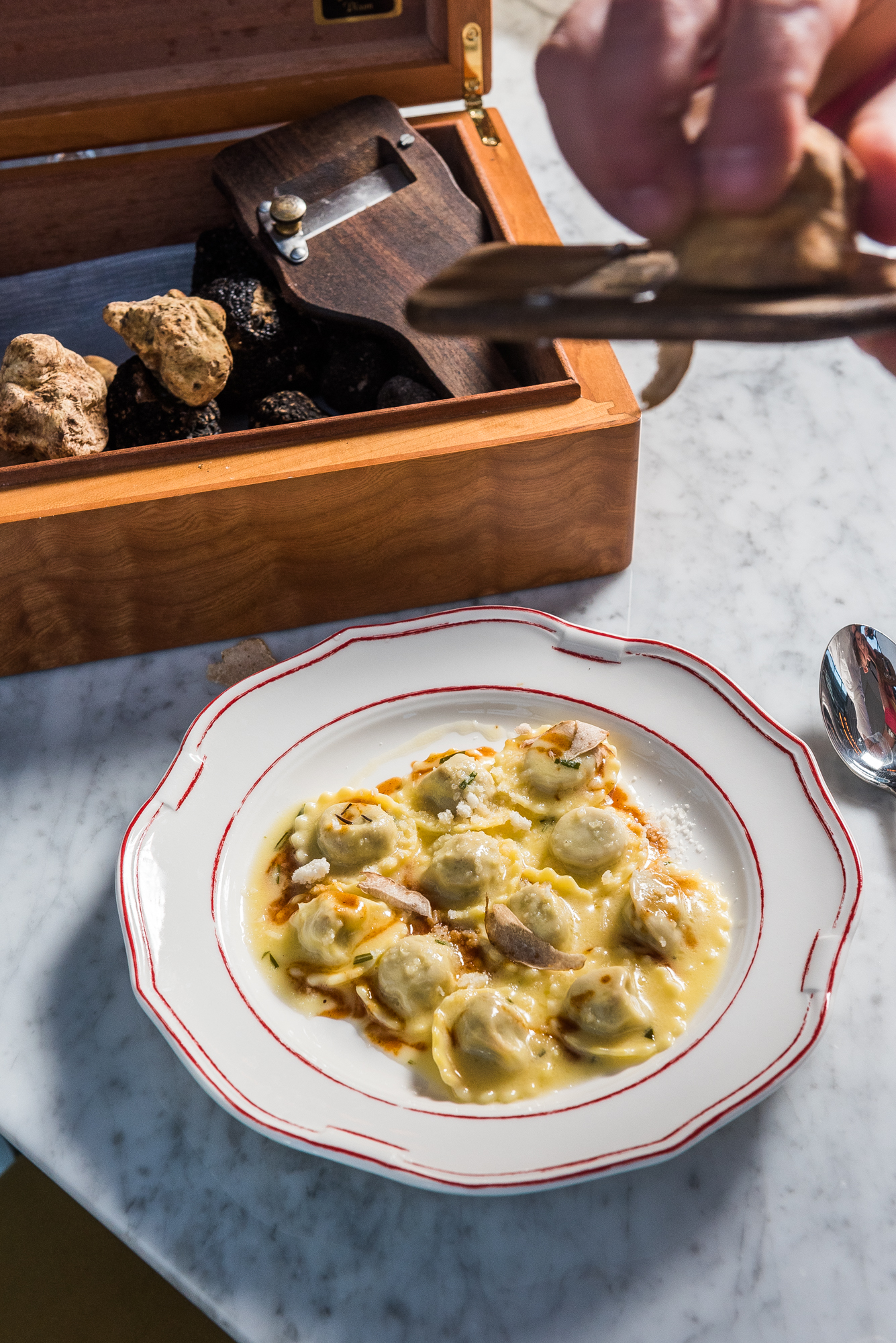 Nicholas Stefanelli shaves white Alba truffles over veal ravioli.