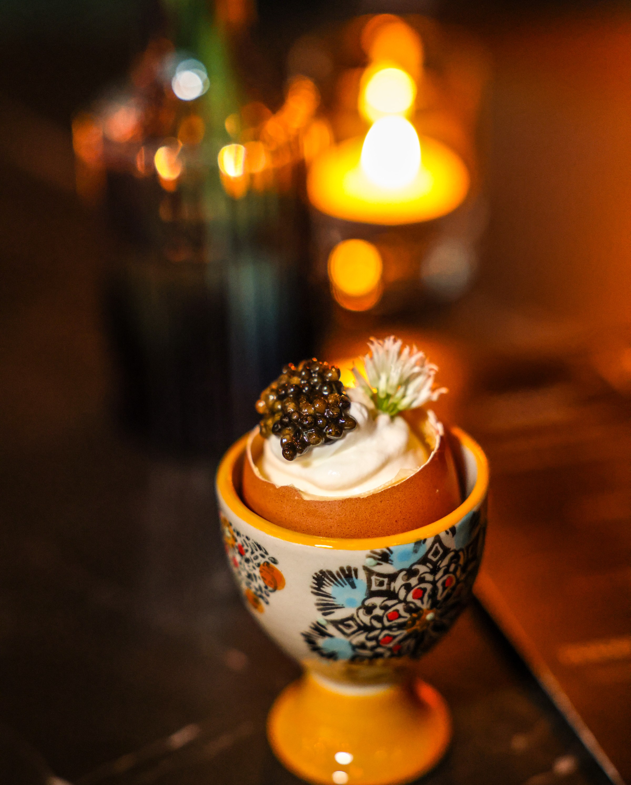 An egg with a savory egg custard, caspian osetra caviar, labneh, and chive blossom.