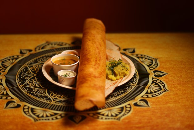 A Ghee Masala Dosa, featuring a crispy Indian crepe made out of urad lentil and rice batter wrapped around a potato filling, is served with tomato chutney, coconut chutney and a spicy stew called sambar at Mylapore in San Jose. (Aric Crabb/Bay Area News Group)