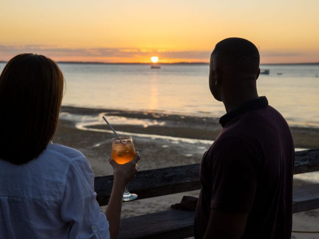 two people drinking cocktails at sunset bar, kingfisher bay resort