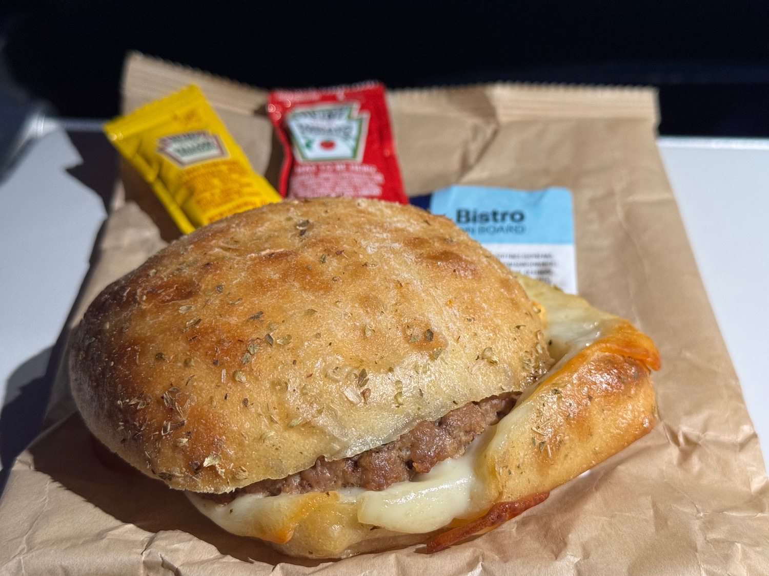 a burger with sauces on a brown paper
