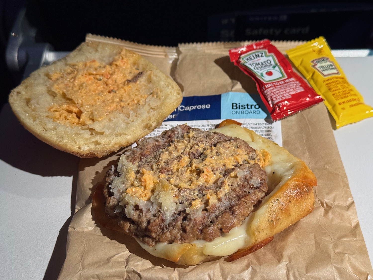 a burger with cheese and sauce on a paper bag