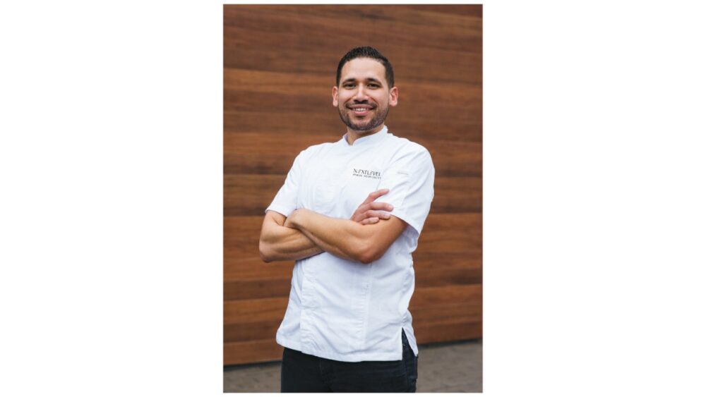 Chef Jacob Rios, culinary director for Next Level Brands, standing with arms crossed