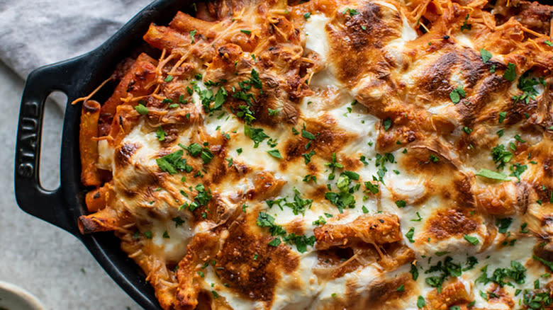 Cheesy baked ziti in black baking dish