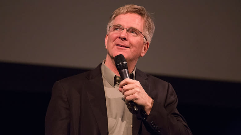 Rick Steves speaking into a microphone