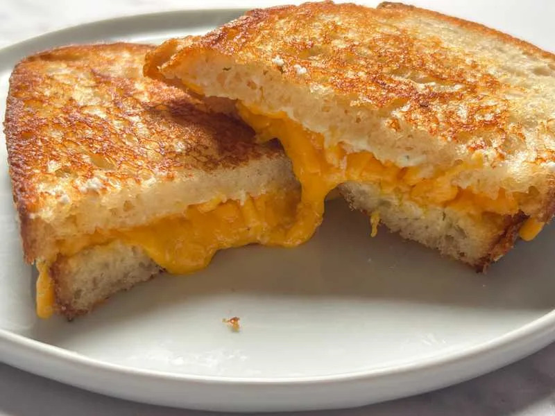 Sliced grilled cheese on plate.