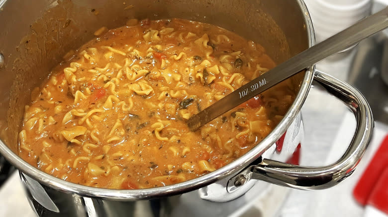 Lasagna soup simmers in a large a stainless steel pot in a commericial kitchen