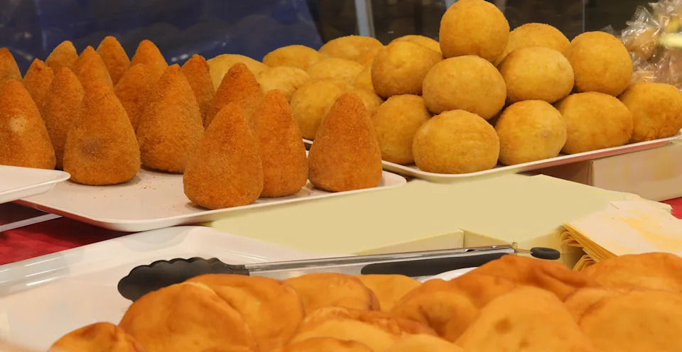 very big fried rice balls made with ham and cheese also known as arancini or arancine a traditional dish from island of Sicily