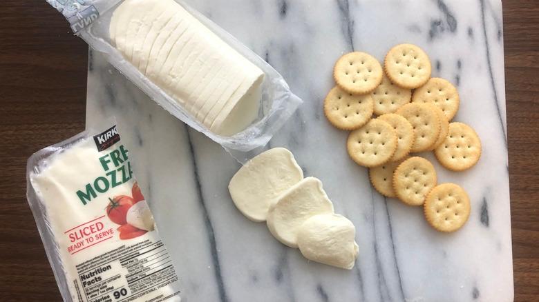 Kirkland Signature mozzarella cheese on board with crackers.