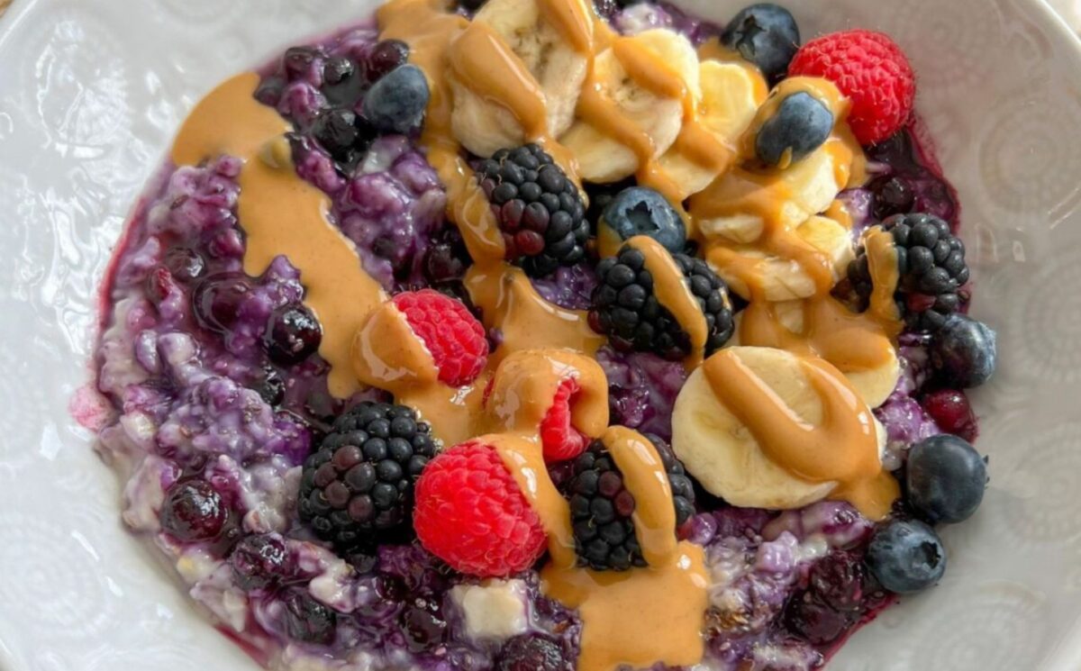 a bowl of 5-minute blueberry superfood oats with banana, nut butter, mixed berries, and chia seeds for vegan recipes for one