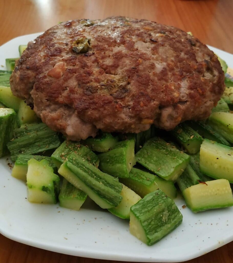 Giant homemade burger on a bed of Roman-style zucchini. [OC]