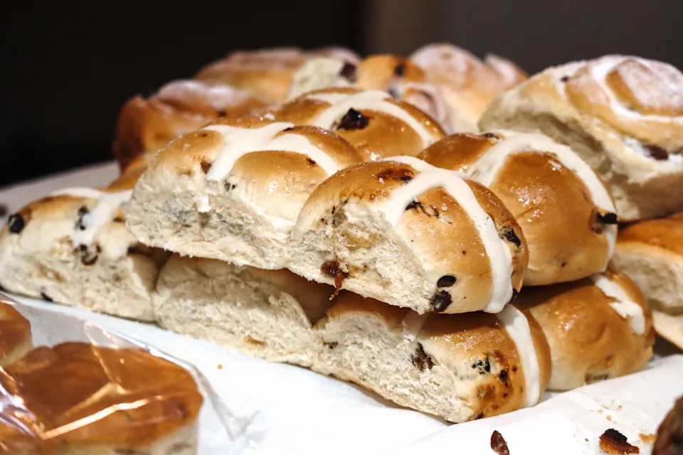 Freshly baked hot cross buns with icing and raisins on display at a local bakery in Cardiff