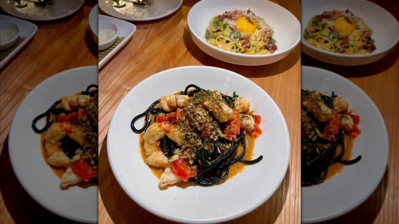 bowl of perciatelli nero pasta with crab, Calabrian chili, tomato, and breadcrumbs in bowl at L'Artusi restaurant in New York City
