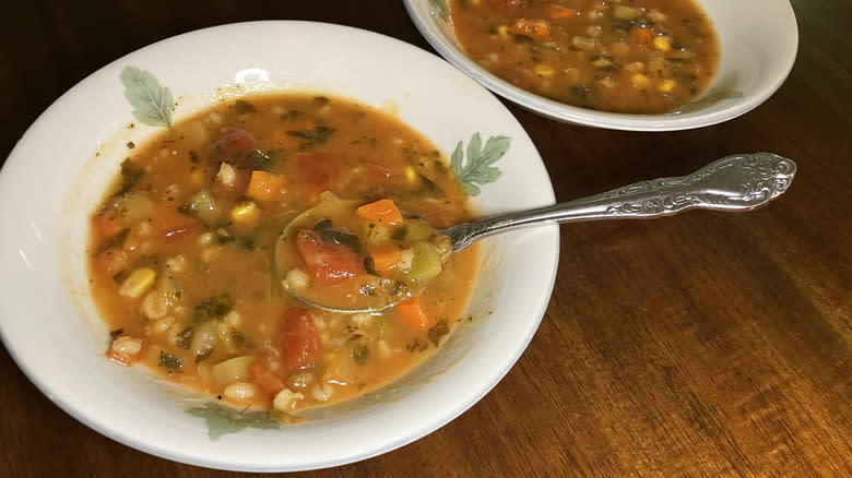 two bowls of Cedar Lane Organic Chopped Vegetable & Barley Soup full of vegetables in a tomato broth