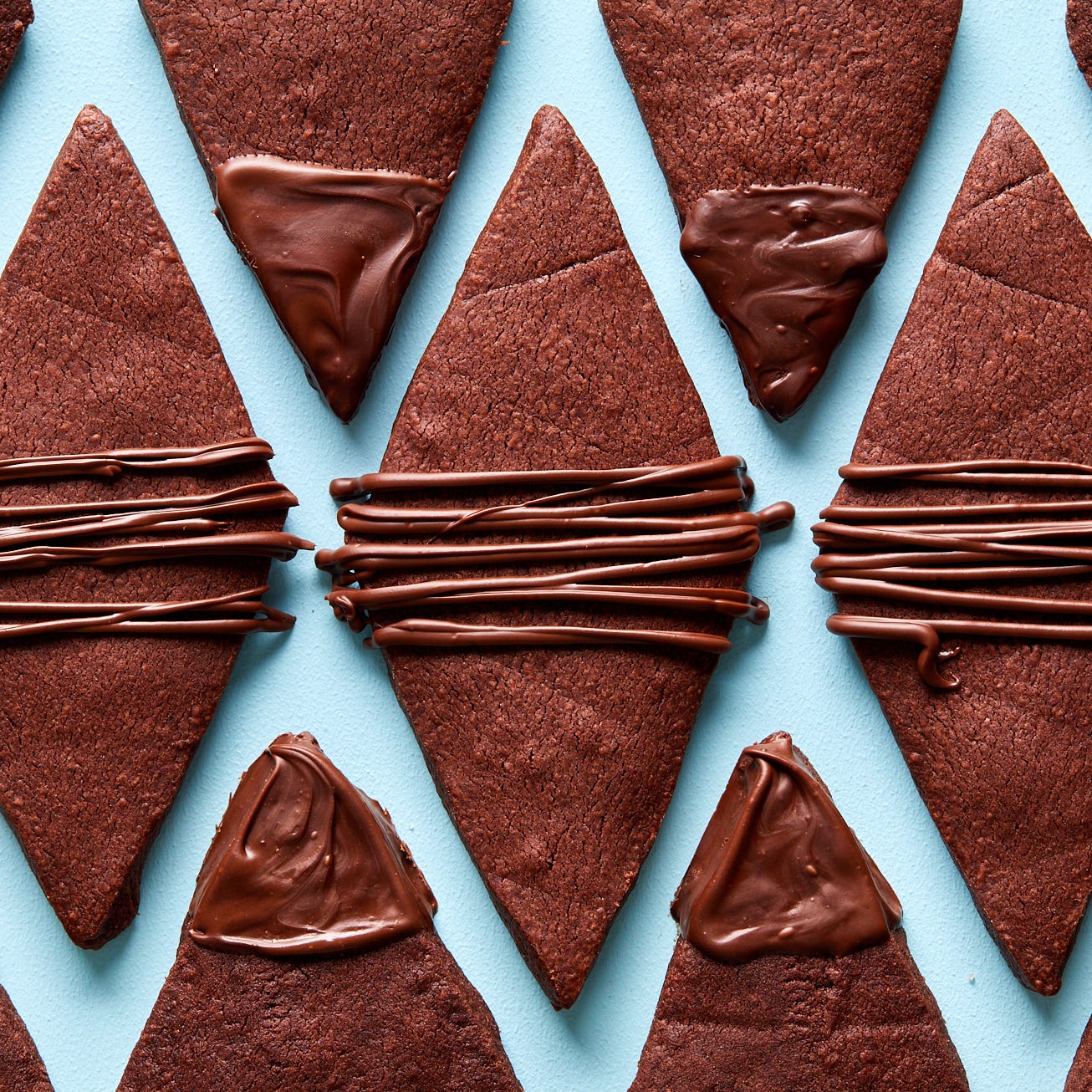 chocolate shortbread cookies shaped like diamonds with a chocolate drizzle