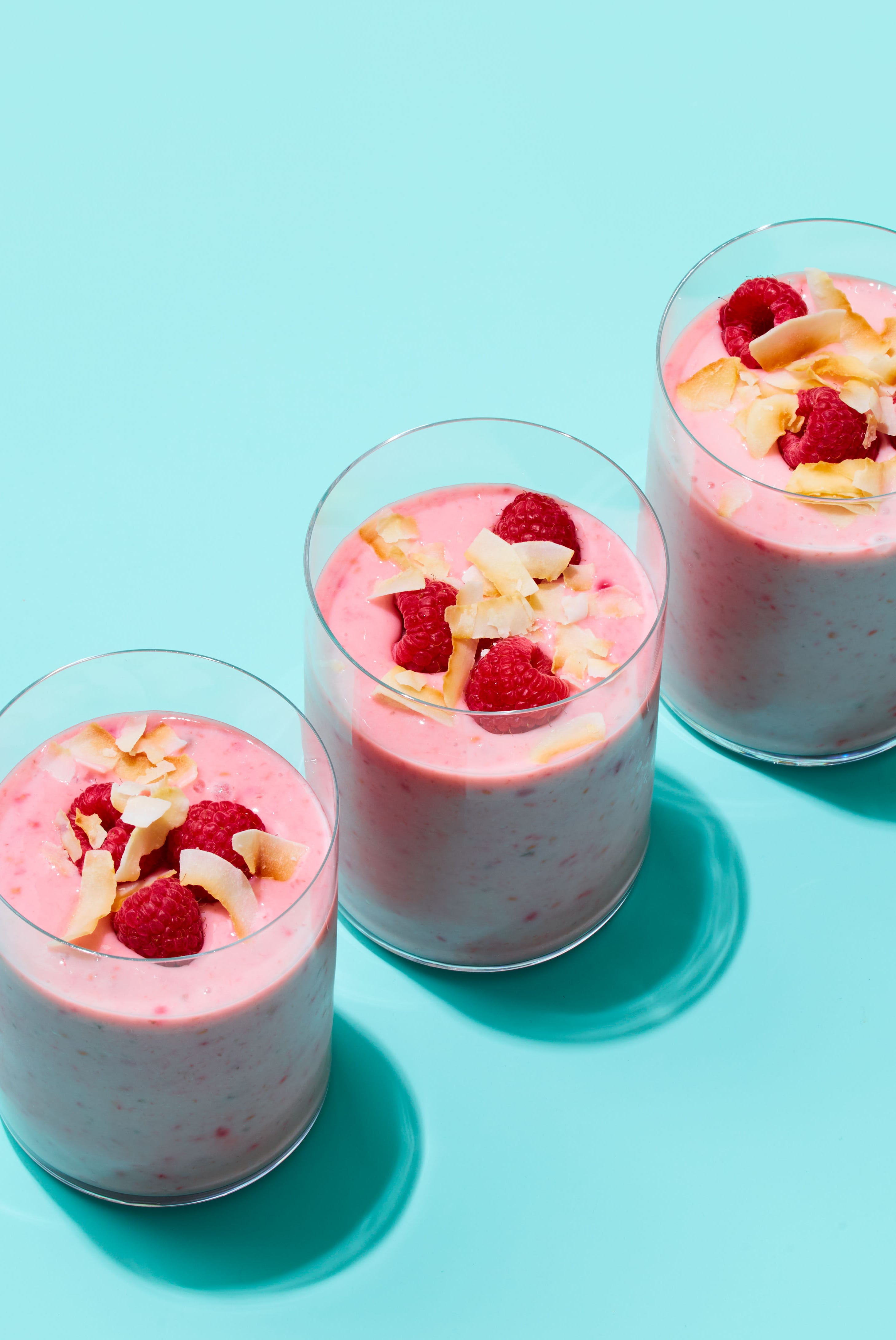 three glasses of pink coconut raspberry smoothie