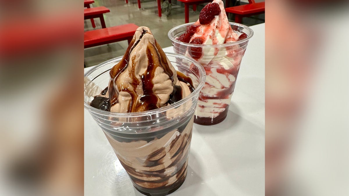 Two ice cream sundaes available as a special treat at the food court at Costco, one chocolate topped with chocolate syrup and the other a strawberry version.
