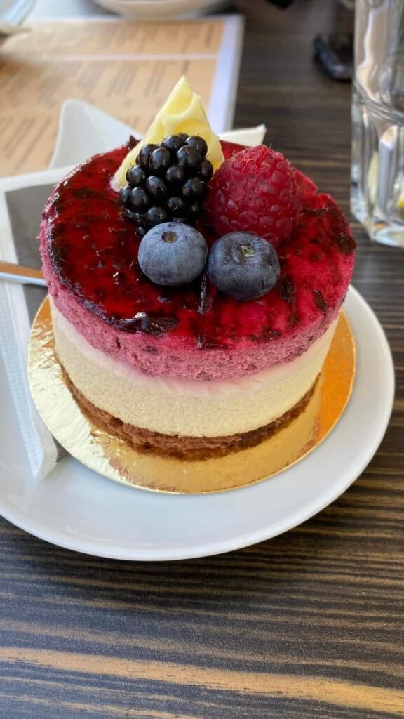 Triple layer mixed berry mousse cake with fresh blackberries and blueberries
