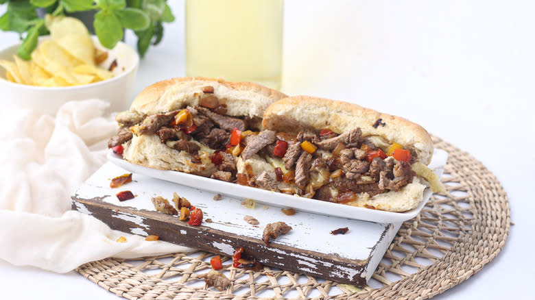 Philly cheesesteak sandwich on white rectangular plate