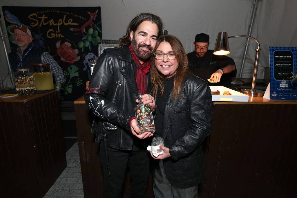 Rachel Ray and John Cusimano pose at the Staple Gin booth during the Blue Moon Burger Bash 2.0 presented by Pat LaFrieda Meats hosted by Brooklyn Beckham and Rachael Ray hosted by Food Network New York City Wine & Food Festival presented by Invesco QQQ on October 17, 2025 in New York City.
