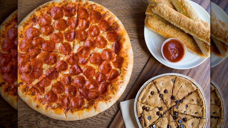 Hand-tossed pepperoni pizza, bread sticks, and cookie from Pizza Hut on table