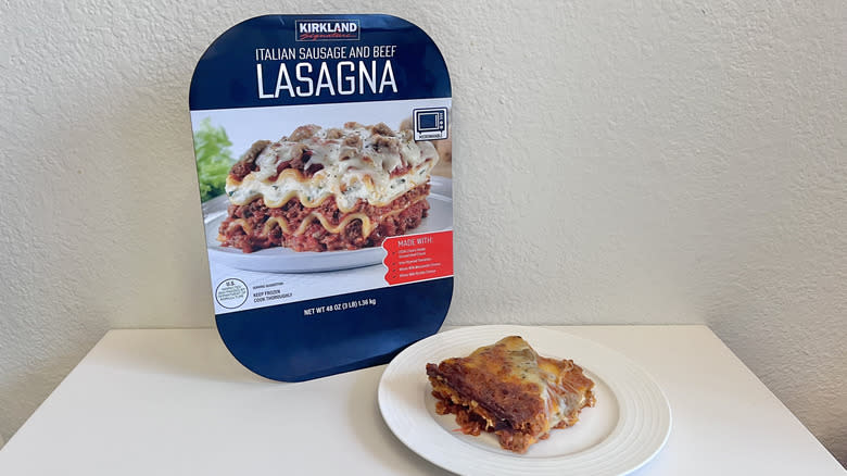 Big piece of Kirkland Signature sausage and beef lasagna with the package leaning against a wall