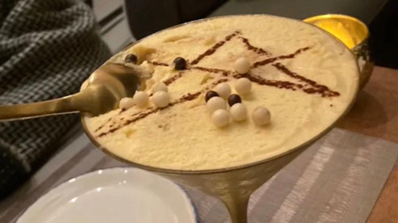 Close-up view of espresso martini at La Stella Cucina Verace, with star and edible pearls on the foam with dim evening lighting