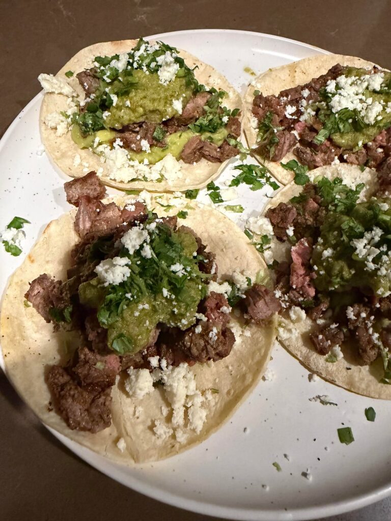 Beef fajita tacos, guacamole, Spicy Verde sauce, cilantro, queso fresco