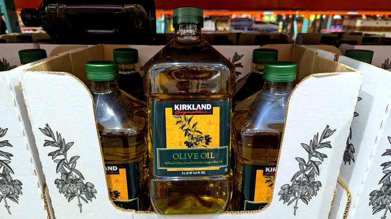 Plastic jugs of Costco Kirkland Signature olive oil inside white cardboard box