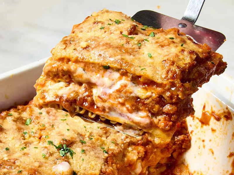 A slice of lasagna lifted on a spatula