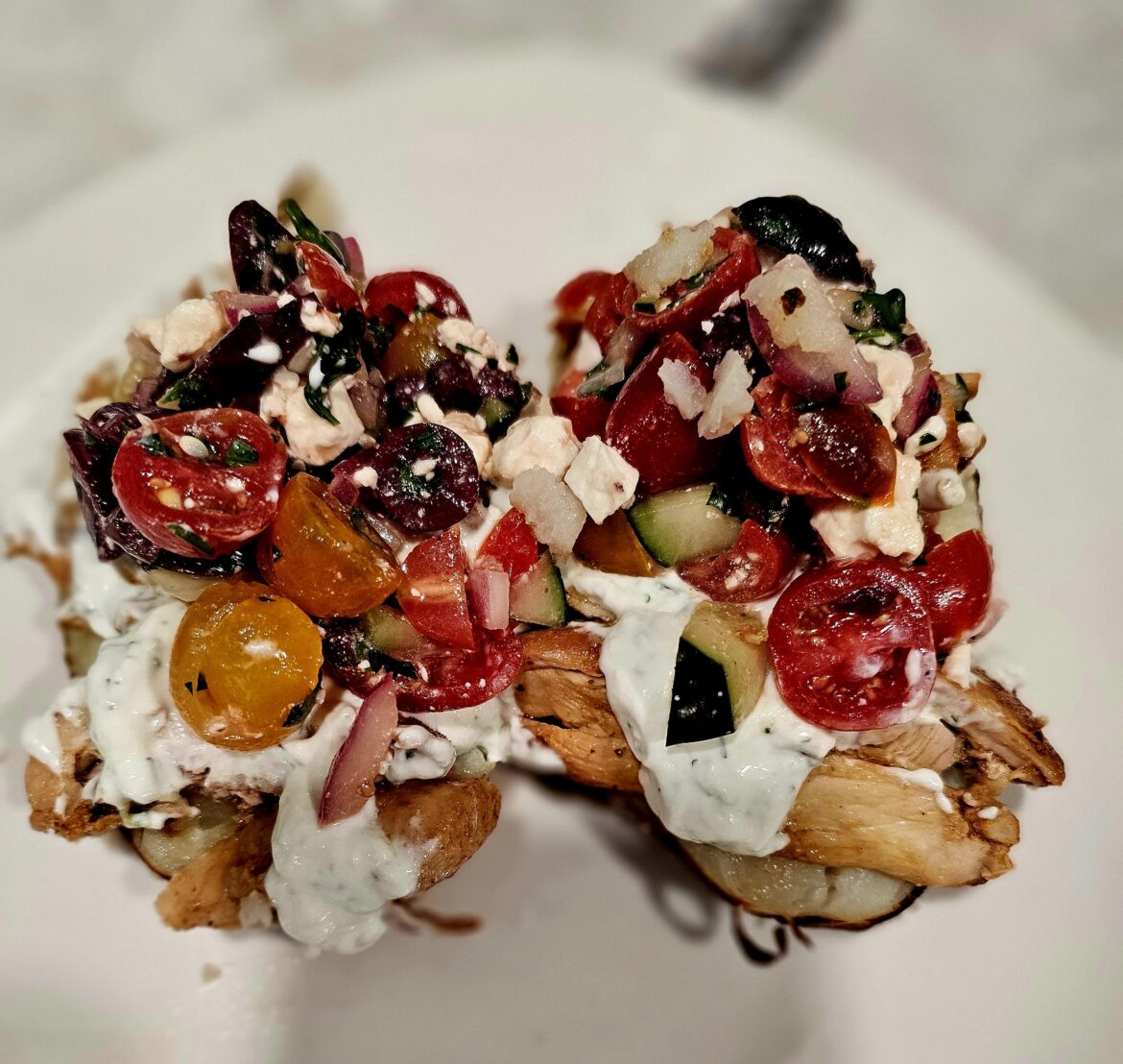 Greek Chicken with salad and tzatziki over baked potato