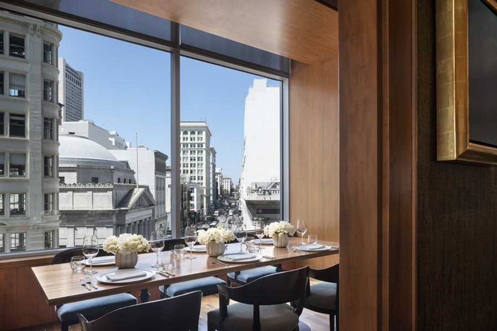 Elegant urban dining room with large window view of city buildings.