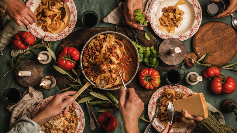 four people eating Italian dinner family style