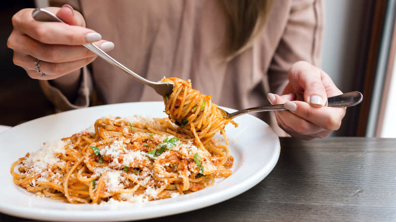 woman eating from a plate of spaghetti