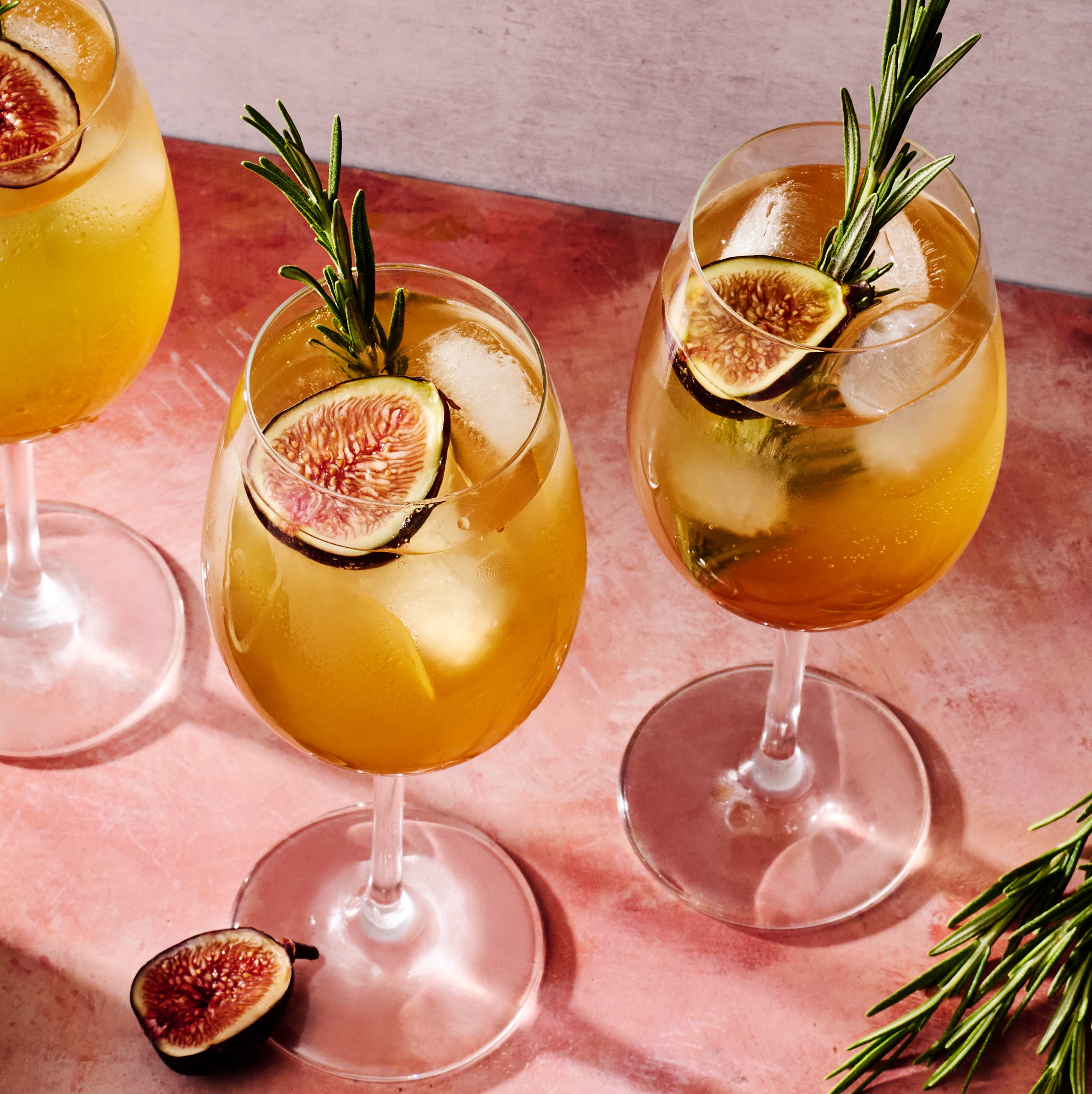 figgy spritz cocktail with a fig and rosemary garnish
