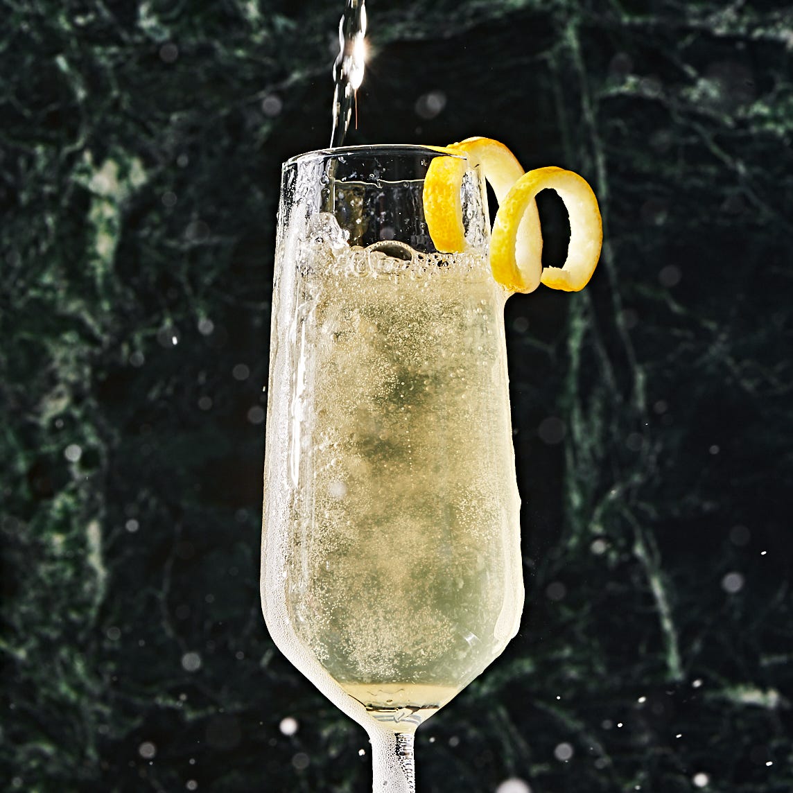 french 75 in a flute garnished with a lemon twist