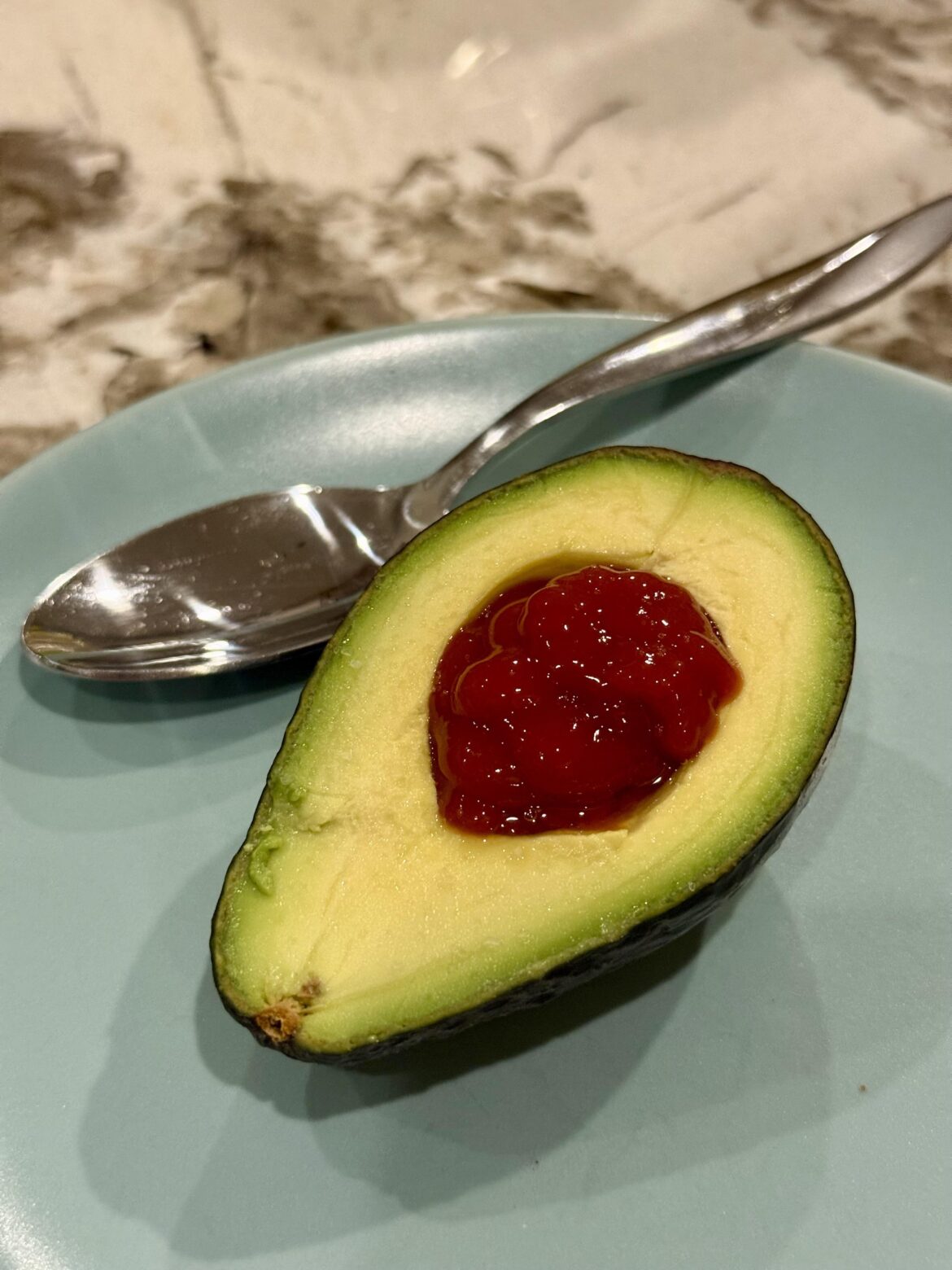 Is this stupid food? It was my grandma’s favorite snack - pitted avocado with ketchup and salt. Eaten with a spoon like ice cream