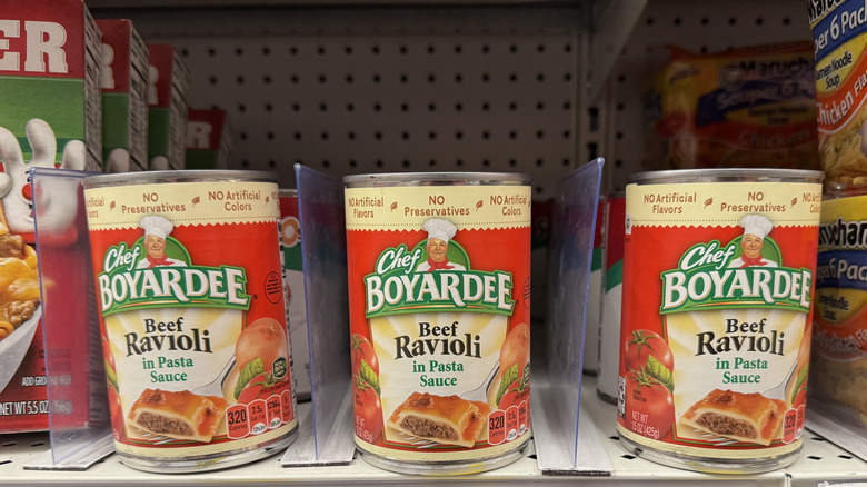 A row of Chef Boyardee Ravioli cans on a shelf