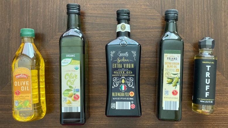 Selection of Aldi olive oils in a row on a wooden table