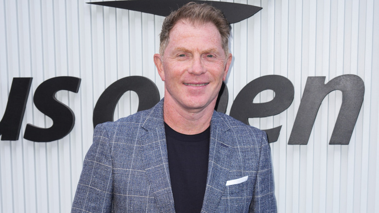 Bobby Flay in front of U.S. open sign