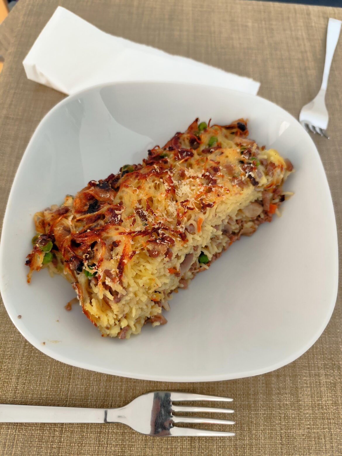 Baked tagliolini with mushrooms peas and ground beef