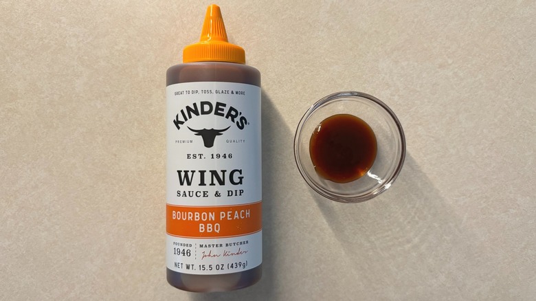 Kinder's Bourbon Peach BBQ Wing Sauce and Dip bottle and sauce in glass ramekin