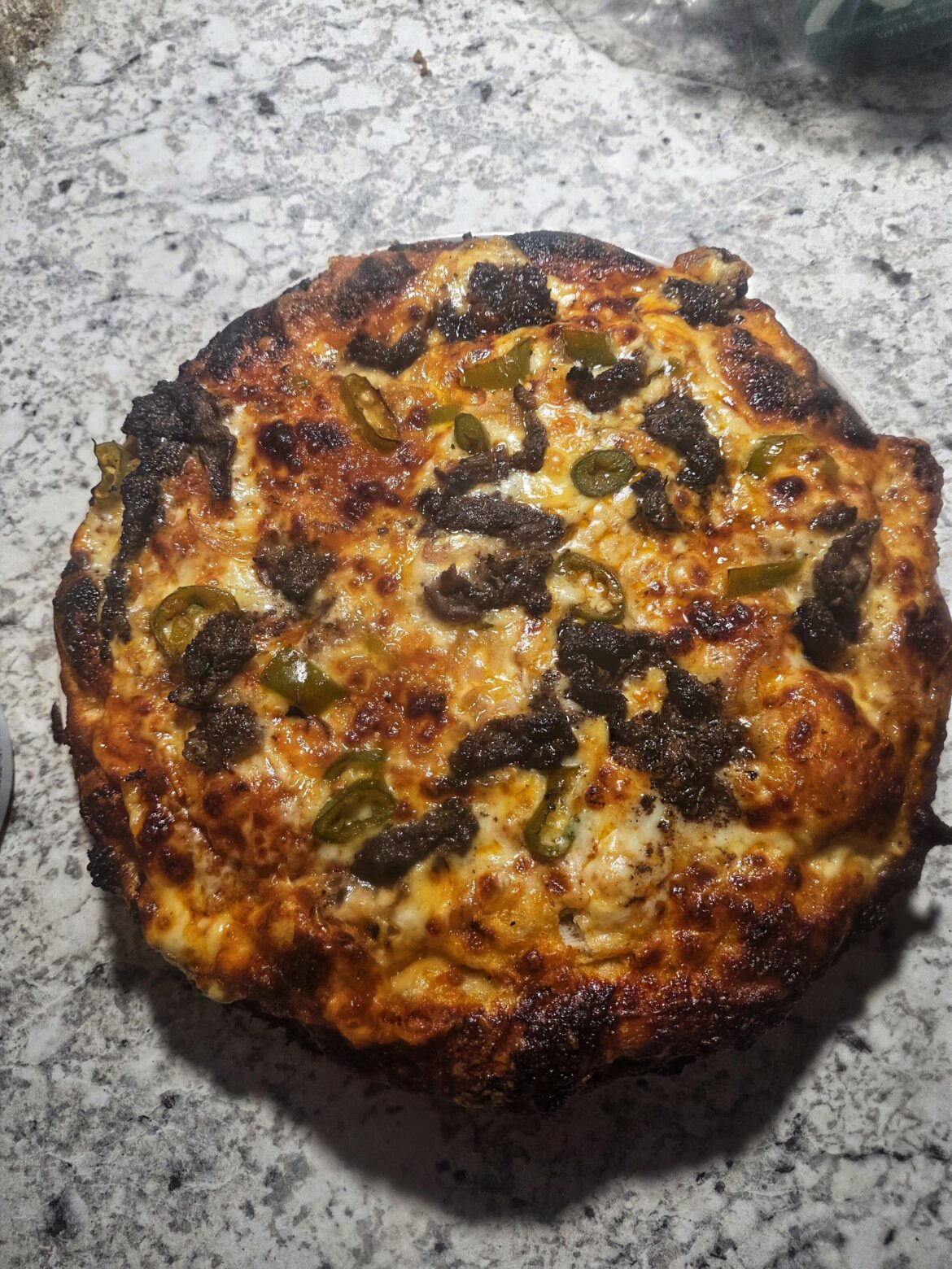 Jerk marinated shaved beef, Serrano, shallot, sharp cheddar/gouda/mozz. Tasted better than it looked