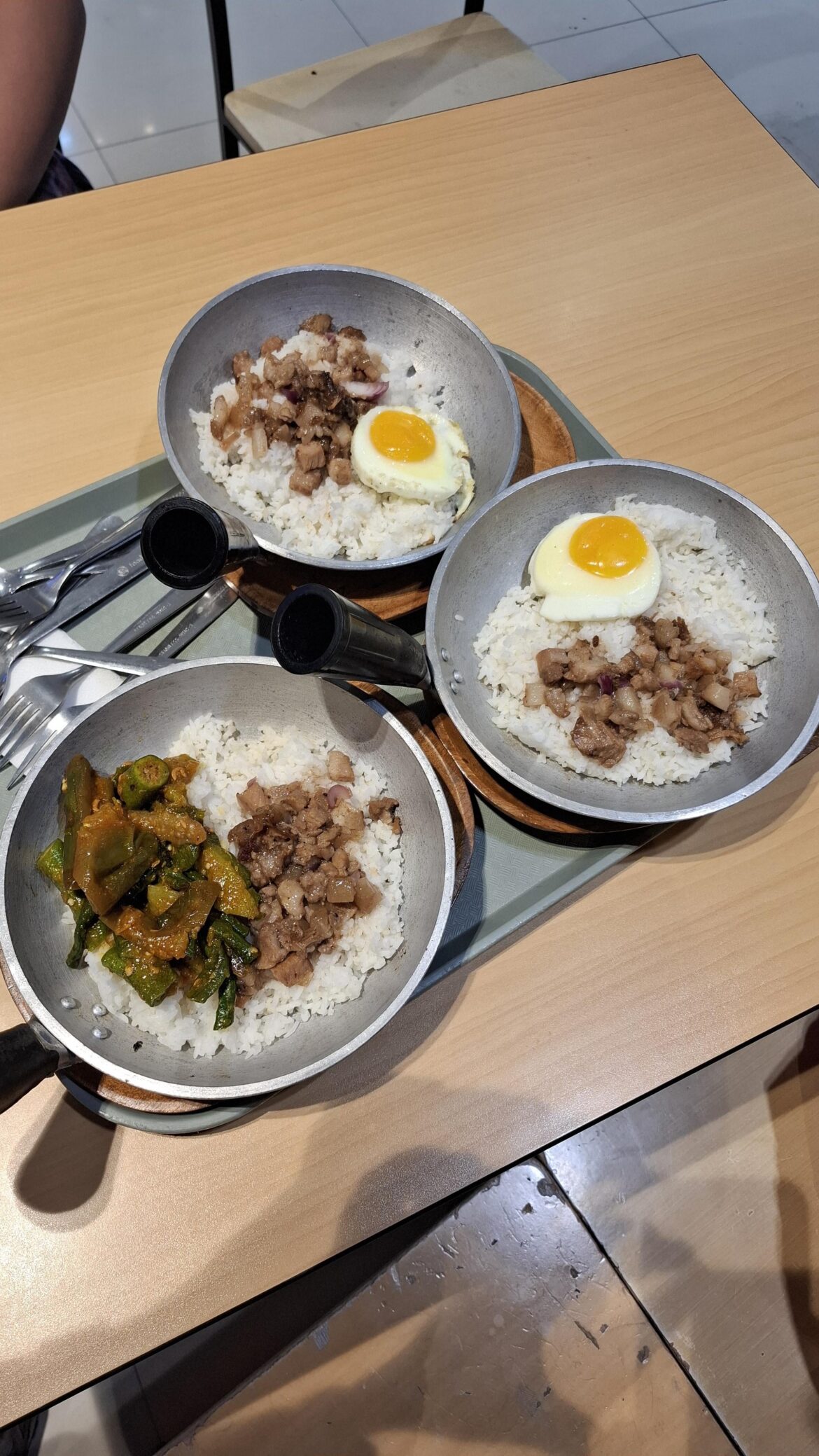 Pork Sisig Meal Served at a Hot Mini Wok that is Placed Ontop of a Wooden Plate
