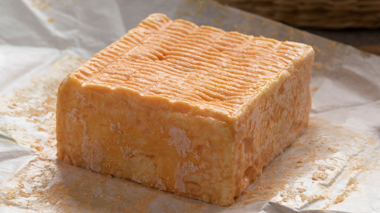 A block of Limburger cheese on top of its wrapping paper